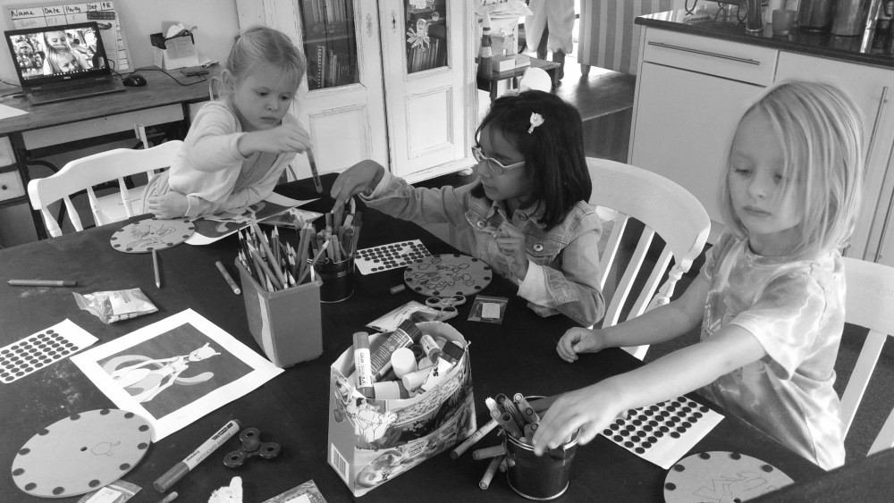 Children decorating cardboard discs at a science club table